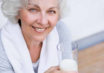 Ältere Frau mit einem Gals Milch in der Hand