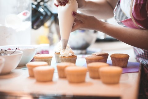 Muffins werden mit Sahnehäubchen verziert